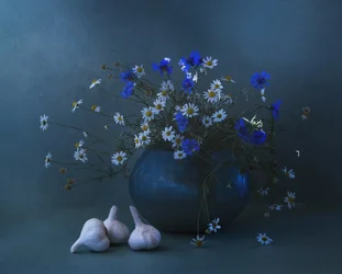 Naturaleza muerta con ajo y margaritas azules