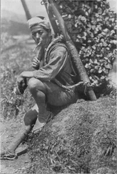 Coolie de mediana edad sentado apresuradamente en la orilla para pasarnos revista, c. 1900, 1921