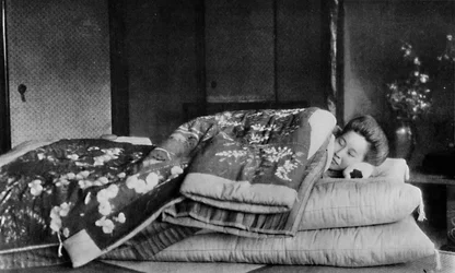 Saki, la ama de llaves duerme en un colchón con almohada dura bajo un kimono acolchado, c. 1900, 1921