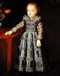 Retrato de un niño de pie junto a una mesa