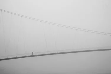 Paseo solitario por un puente envuelto en niebla