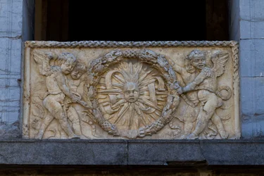 Placa de balaustrada con sol radiante en guirnalda, bajorrelieve en la fachada de la iglesia de San Sebastiano