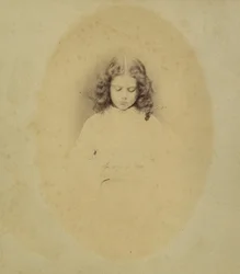 Edith Liddell sentada junto a un jarrón de dedaleras