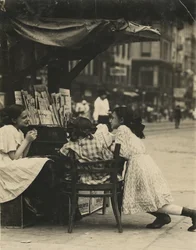 Tres chicas trabajando en un puesto de periódicos en Canal Street, Nueva York.