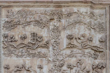 Naamah enseñando a leer a un niño y Tubal-cain golpeando campanas con un martillo; Enos, hijo de Seth, dibujando con compás, Historias del Génesis, bajorrelieves de Lorenzo Maitani, primer pilar, fachada lateral de la catedral de Orvieto, Umbría, Italia