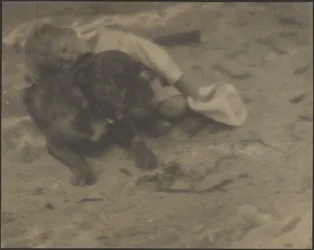 [Niño descansando sobre un perro]