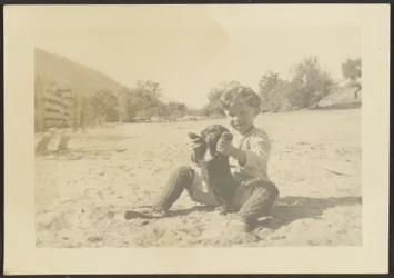 [Niño y perro en la playa]