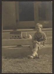 [Niño con juguetes en los escalones]