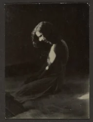 [Bailarina arrodillada en sombra profunda]