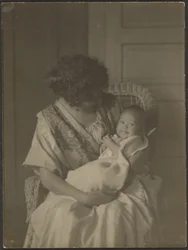 [Florence sostiene a su bebé en una mecedora]