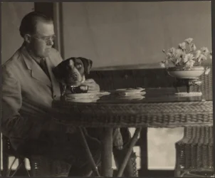 [Hombre y perro sentados a la mesa]