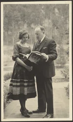 [Hombre y mujer de pie al aire libre con una revista]