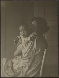 [Madre sosteniendo a su bebé en una silla]