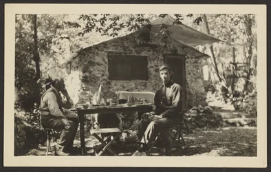 Comida al aire libre junto a una casa de piedra en el bosque