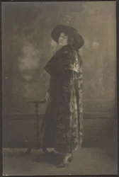 [Retrato de mujer con abrigo largo ante el tapiz]