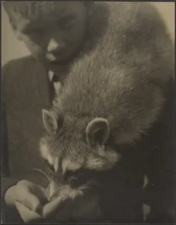 [Retrato de un niño dando de comer a un mapache]
