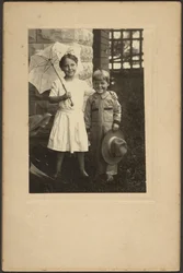Retrato de una niña con paraguas y un niño con sombrero
