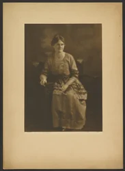 [Retrato de una mujer sentada con vestido y lazos.]