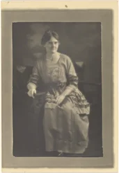 [Retrato de una mujer sentada con vestido y lazos.]