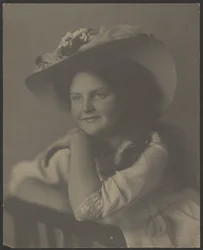 [Retrato de una mujer joven apoyada en una silla]
