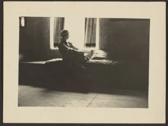 [Mujer sentada en la ventana]