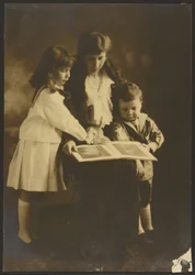 [Mujer y niños con libro ilustrado]
