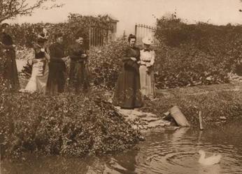 Un grupo de mujeres junto a un estanque de patos