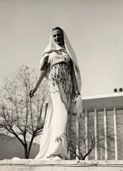 Modelo con vestido de noche de tela estampada floral, creado por la casa de alta costura "Lamma". El artículo se completa con un largo velo.