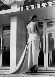 Modelo vista desde atrás lleva un vestido de noche creado por la casa de alta costura "Graldi". El artículo se caracteriza por una espalda descubierta y una cola.