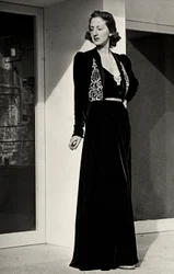 Modelo con vestido de noche largo de terciopelo oscuro con decoración bordada, creado por la casa de alta costura italiana "Fercioni".