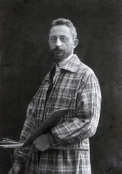 Retrato de tres cuartos del pintor Guido Spadolini. Lleva una bata larga y sostiene pinceles y paleta en su mano izquierda, 26/11/1901