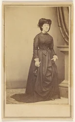 [Mujer no identificada con sombrero y vestido largo oscuro.]