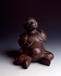 Arte precolombino, civilización maya, período inicial: vaso antropomorfo de arcilla que representa a un hombre sentado con las manos en el pecho y usando una máscara de mono con la boca abierta. De Uaxactún, Guatemala. Dim. h. 22,5 x ancho 19 cm Guatemala,