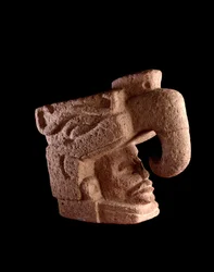 Arte precolombino, civilización maya, período preclásico: escultura de piedra que representa la cabeza de un hombre emergiendo de la boca de un dios zoomorfo que se asemeja al ave celestial. Dim. 38 x ancho 46 cm Guatemala, Museo Nacional de Arqueología y 
