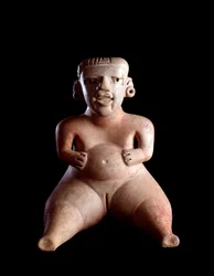 Arte precolombino, civilización maya, período preclásico: estatuilla de arcilla que representa a una mujer sentada, con el vientre hinchado y las piernas separadas (¿parturienta?). De Kaminaljuyú, Guatemala. Dim. 19 x 25 cm Guatemala, Museo Nacional de Arq