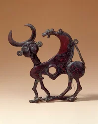 Antigüedades orientales: placa de mandíbula de bronce que representa un monstruo androcefálico pisoteando una cierva. De Luristán. 750 a.C. París, Museo del Louvre