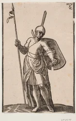 Soldado de pie, visto de frente; tocado con una parte superior alta y delgada; en la mano derecha una lanza, en el brazo izquierdo un escudo visto desde adentro