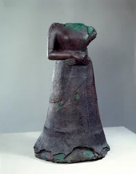 Civilización elamita: estatua de bronce de la reina Napir Asu con inscripción elamita. 1250 a. C. Del yacimiento de Susa, Irán. H 1,29 x 0,73 m. París, Museo del Louvre