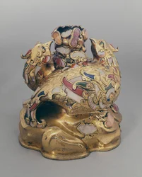 Vasija de vino china de cobre dorado en forma de fénix sobre una roca