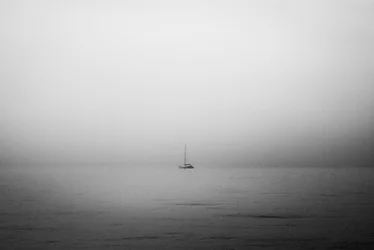Un velero solitario entre la niebla