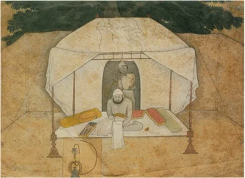 Balwant Singh sentado escribiendo en una cama de campaña