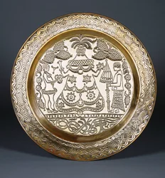 Un cargador de bronce Efik con una figura femenina central con túnica y dos sirvientes sosteniendo un abanico y un paraguas