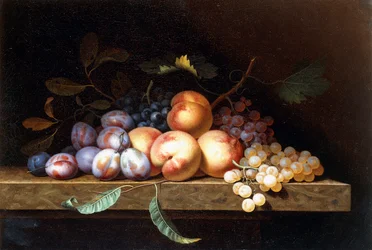 Duraznos, ciruelas y uvas en un borde de piedra