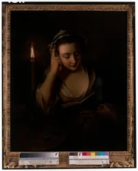 Una joven leyendo a la luz de las velas