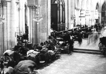 Personas refugiadas en la catedral de Caen, julio de 1944 (foto b/n)