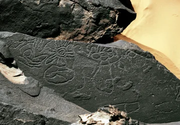 Prehistoria, arte rupestre: roca funeraria con formas en el estilo de Tazina