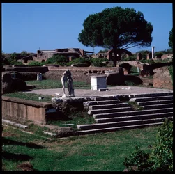 Arte romano: vista de las ruinas del templo de Hércules y estatua de Gaius Cartilius Popplicola, ciudadano de Ostia