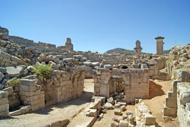 Vista a través de la entrada abovedada del teatro de Xanthos hacia el foso de la Orquesta, mostrando la columna y la tumba de la Arpía, Xanthos, Turquía
