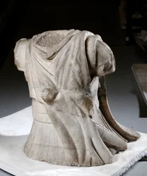 Torso esculpido de un jinete con capa pesada desgastada