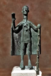 Cultura nurágica (nuraghi) sarda: estatuilla de bronce de viajero con un bastón y cubierto con una capa. Siglos VIII-VII a.C. Cagliari, Museo Nacional Arqueológico, Cerdeña, Italia